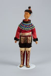 Image of West Greenland doll in costume, tall red boots, beaded collar